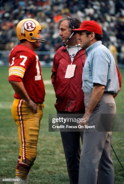 Head coach George Allen of the Washington Redskins talks with quarterback Billy Kilmer on the sidelines during an NFL football game circa 1971 at RFK...