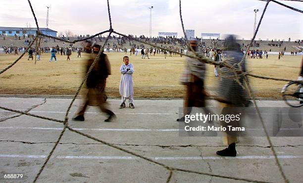 Spectators walk in Kabul Stadium after watching a soccer match December 23, 2001 in Kabul, Afghanistan. Halftime executions were frequently held in...