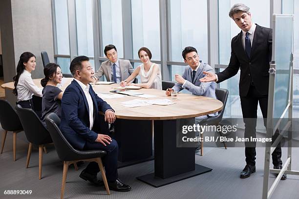 business people having meeting in board room - business talk sit men stock-fotos und bilder