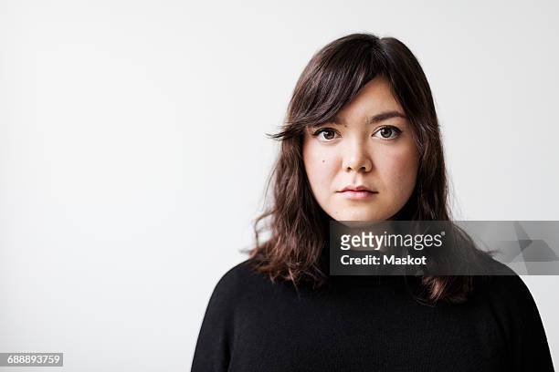 portrait of serious young woman against white background - expresión en blanco fotografías e imágenes de stock