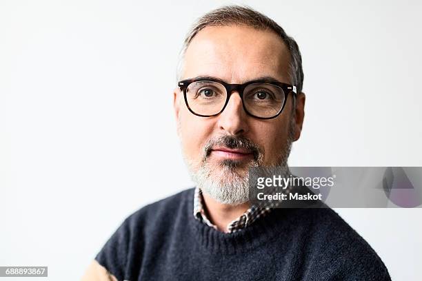 portrait of confident mature man wearing eyeglasses against white background - solo un uomo maturo foto e immagini stock