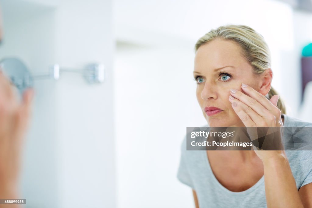 Analysing her skin for any blemishes