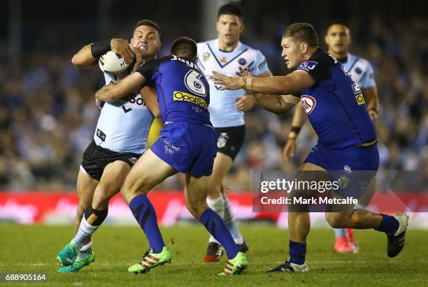 Chris Heighington of the Sharks is tackled by Matt Frawley of the Bulldogs during the round 12 NRL match between the Cronulla Sharks and the...