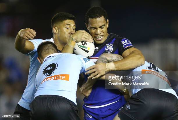 Will Hopoate of the Bulldogs is tackled by Jayden Brailey and Luke Lewis of the Sharks during the round 12 NRL match between the Cronulla Sharks and...