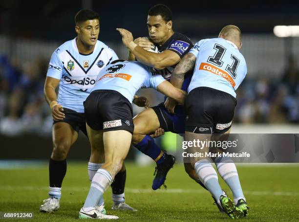 Will Hopoate of the Bulldogs is tackled by Jayden Brailey and Luke Lewis of the Sharks during the round 12 NRL match between the Cronulla Sharks and...