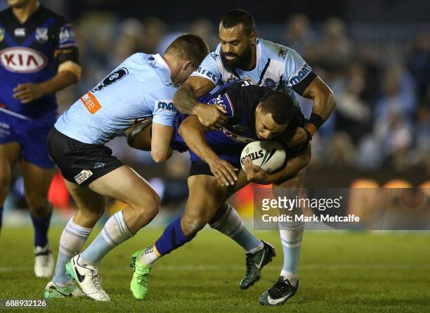 Moses Mbye of the Bulldogs is tackled by Jayden Brailey of the Sharks during the round 12 NRL match between the Cronulla Sharks and the Canterbury...