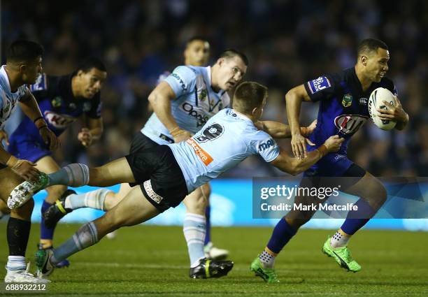 Moses Mbye of the Bulldogs is tackled by Jayden Brailey of the Sharks during the round 12 NRL match between the Cronulla Sharks and the Canterbury...