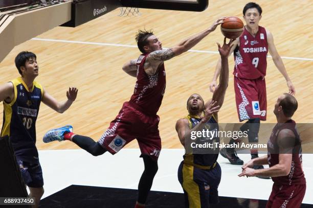 Jeff Gibbs of the Tochigi Brex is blocked by Ryan Spangler of the Kawasaki Brave Thunders during the B. League final match between Kawasaki Brave...