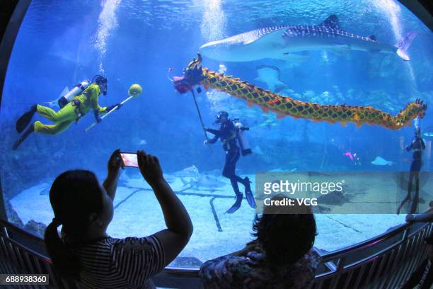 Divers rehearse dragon dance in the water to celebrate the Dragon Boat Festival at Haichang Ocean Park on May 27, 2017 in Yantai, Shandong Province...