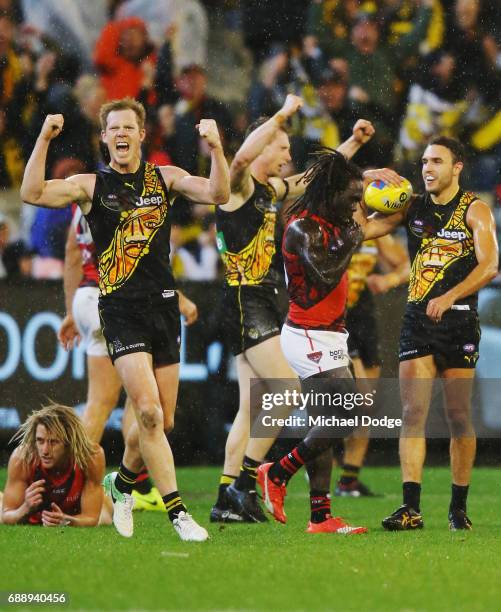 Jack Riewoldt and Shane Edwards of the Tigers celebrates the win on the final siren as Dyson Heppell of the Bombers and Anthony McDonald-Tipungwuti...