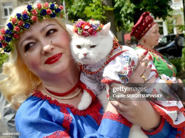 Woman holds a cat wearing a Vyshyvanka, a traditional Ukrainian embroidered blouse, during the Vyshyvankas March in Kiev on May 27, 2017. Kiev...