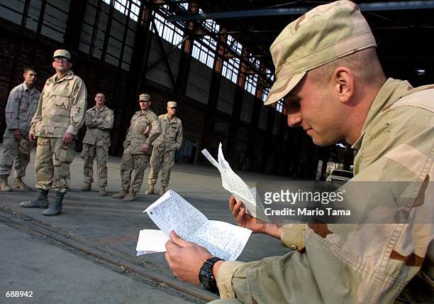 United States Army Sgt. Larry Casanova, of Haddon Township, NJ, reads a letter from his wife after eating Christmas dinner December 25, 2001 at...