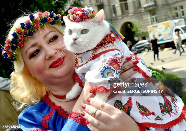 Woman carries a cat wearing Vyshyvanka, traditional Ukrainian embroidered blouses, during the Vyshyvankas March in Kiev on May 27, 2017. Kiev...