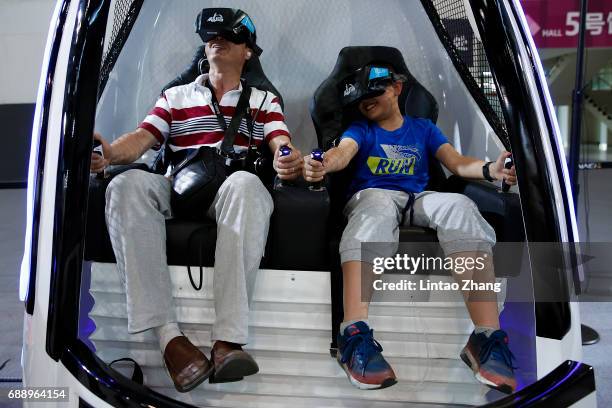 Family wears virtual reality glasses plays a game during the 2017 China International Big Data Industry Expo at Guiyang International Eco-Conference...