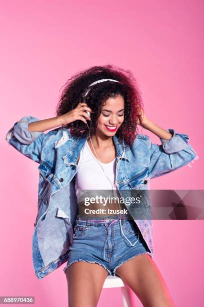 young afro woman listening to music - calções cor de rosa imagens e fotografias de stock