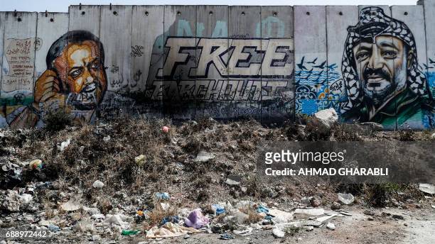 Picture taken on May 27, 2017 between Jerusalem and the West Bank city of Ramallah shows a mural of Fatah leader Marwan Barghuti and late Palestinian...