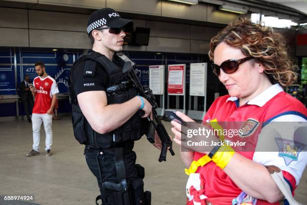 An armed police officer patrols as football fans arrive at Wembley Park Tube Station ahead of the FA Cup final on May 27, 2017 in London, England....