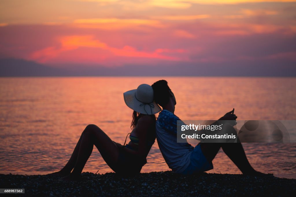 Couple watching sunset on the beach