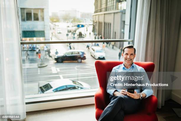 happy businessman relaxing in hotel room - businessman hotel ストックフォトと画像