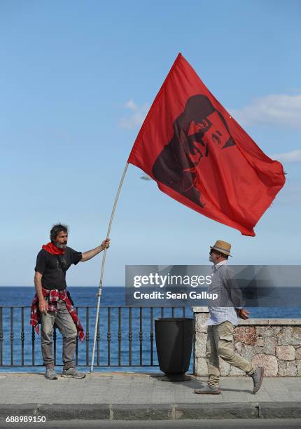 Leftist demonstrator holding a flag of Chinese communist revolutionary Mao Tse-Tung pauses during a march in which several thousand partook to...