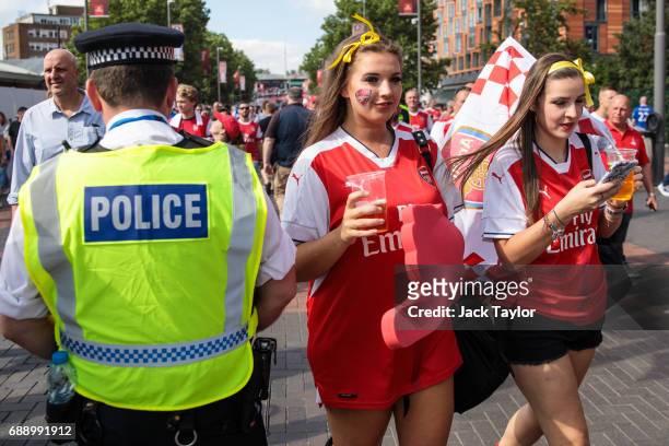 Football fans make their way to Wembley Stadium past a police officer ahead of the FA Cup final on May 27, 2017 in London, England. Football fans...