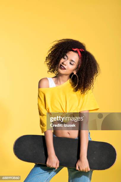 young afro woman holding skateboard - skinny girl stock pictures, royalty-free photos & images