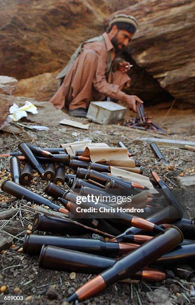 An anti-Taliban fighter looks over .50 caliber machine gun rounds December 26, 2001 at the remains of an Al Qaeda base deep in the Tora Bora valley...