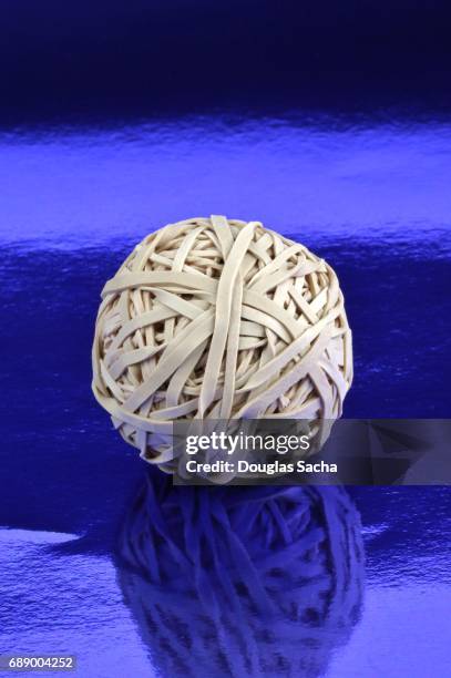 cloe-up of a rubber band ball on a blue background - elastic band ball stock pictures, royalty-free photos & images
