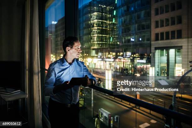 businessman relaxing in the evening in hotel room - mann busines fenster stock-fotos und bilder