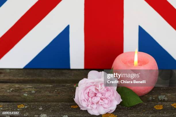 candle and pink rose - bandiera inglese stock-fotos und bilder