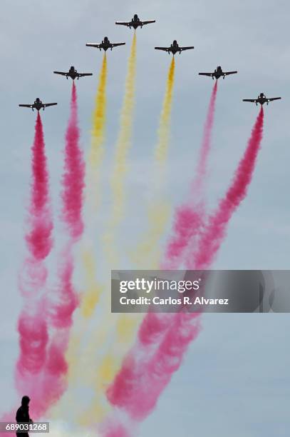 Spanish elite acrobatic flying team 'Patrulla Aguila' perform aerobatics and release trails of red and yellow smoke representing the Spanish flag...