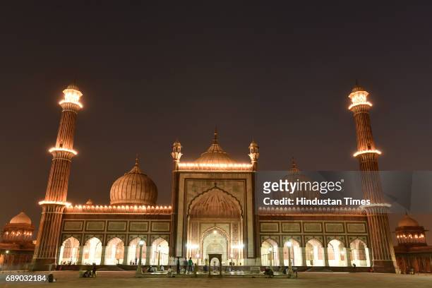 Half Crescent Moon is seen over illuminated Jama Masjid to mark the beginning of the holy fasting month of Ramadan, on May 27, 2017 in New Delhi,...