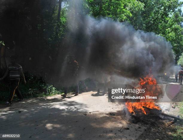 Kashmiri protesters burning a tyre near an encounter site at Saimoh village, in Tral area, on May 27, 2017 about 45 Kilometres south of Srinagar,...