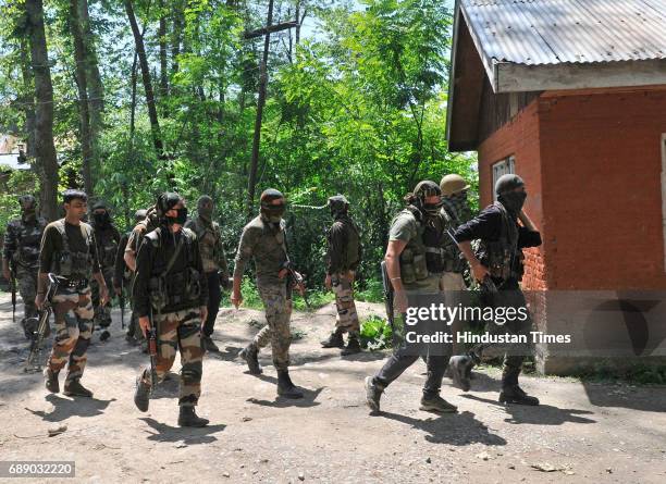 Army soldiers and policemen patrol after a gun battle ends at Saimoh village, in Tral area, on May 27, 2017 about 45 Kilometres south of Srinagar,...