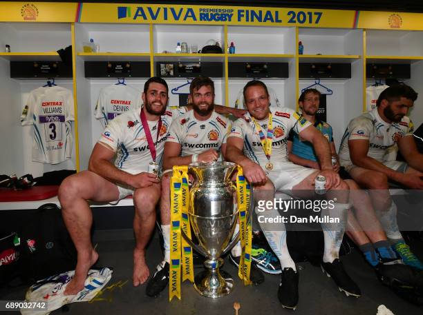 Dave Dennis of Exeter Chiefs, Geoff Parling of Exeter Chiefs and Kai Horstmann of Exeter Chiefs pose with the trophy in the changing room after the...