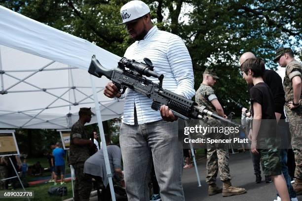 Charles Ricketts holds a gun during Marines Day in Brooklyn's Prospect Park as part of Fleet Week on May 27, 2017 in New York City. Members of the...