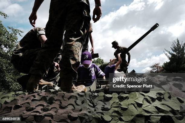 Children play on a light armored vehicle as members of the U.S. Marine Corps mix with the public in Brooklyn's Prospect Park as part of Fleet Week on...