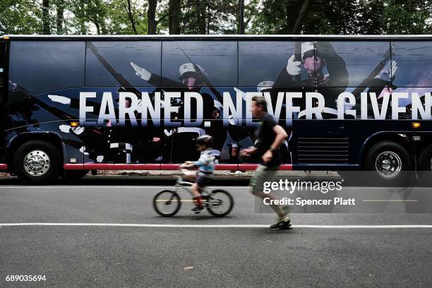 Man and his child run past a Members of the U.S. Marine Corps bus in Brooklyn's Prospect Park as part of Fleet Week on May 27, 2017 in New York City....