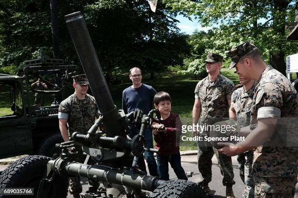 Child plays with a mortar launcher as members of the U.S. Marine Corps mix with the public in Brooklyn's Prospect Park as part of Fleet Week on May...