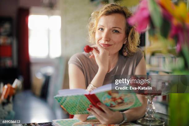 reading a cookbook - reading cookbook stock pictures, royalty-free photos & images