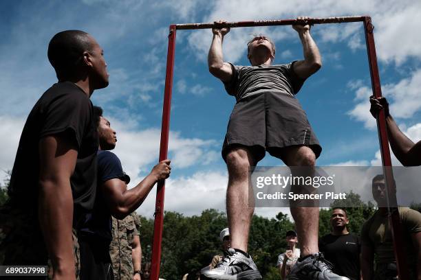 Members of the U.S. Marine Corps watch as Matt Cortright does pull-ups in Brooklyn's Prospect Park as part of Fleet Week on May 27, 2017 in New York...