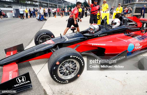Mario Andretti and Good Morning America correspondent Rob Marciano wait in a two seater IndyCar before their lap at the Indianapolis Motor Speedway...