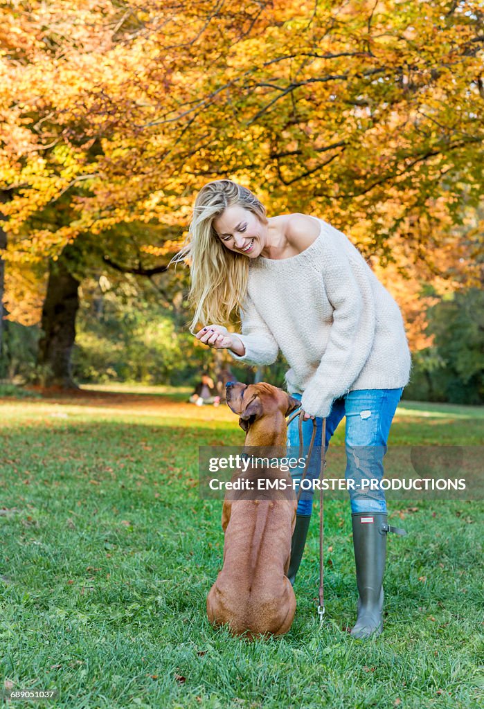 Beauty woman with her dog in a park