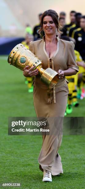 Former world class figure skater Katharina Witt walks on the pitch with the DFB Cup trophy prior to the DFB Cup final match between Eintracht...