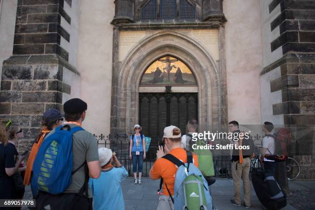 Pilgrims stand in front of the All Saints' Church , the site where the Ninety-five Theses were likely posted by reformer Martin Luther on May 27,...