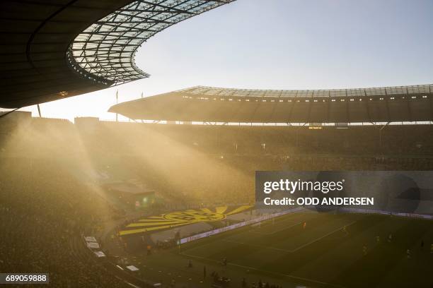 The sun sets as fans watch the German Cup final football match Eintracht Frankfurt v BVB Borussia Dortmund at the Olympic stadium in Berlin on May...