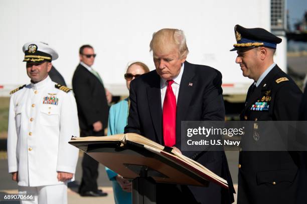 In this handout provided by U.S. Navy, President Donald J. Trump signs the Albo dâOnore, the Sigonella Italian Air Force base guest book at Naval Air...