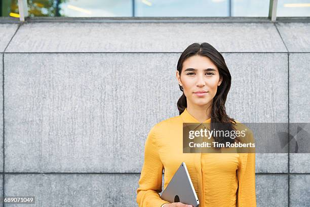 portrait of woman with tablet - yellow wall stock-fotos und bilder