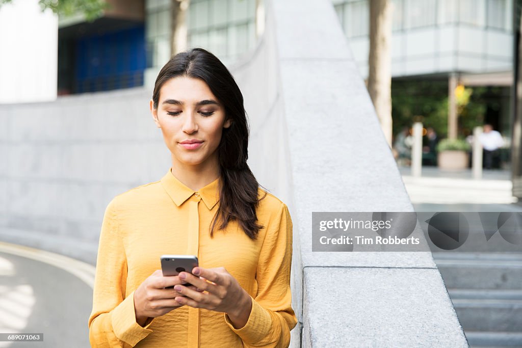Woman using mobile in business district