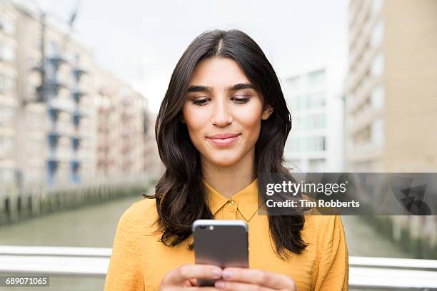 woman using mobile phone - woman looking down smiling stock pictures, royalty-free photos & images